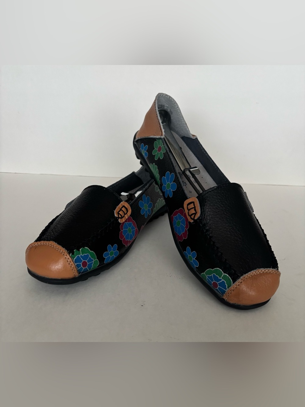 Black Floral Leather Slip-Ons with Tan Toe and Heel